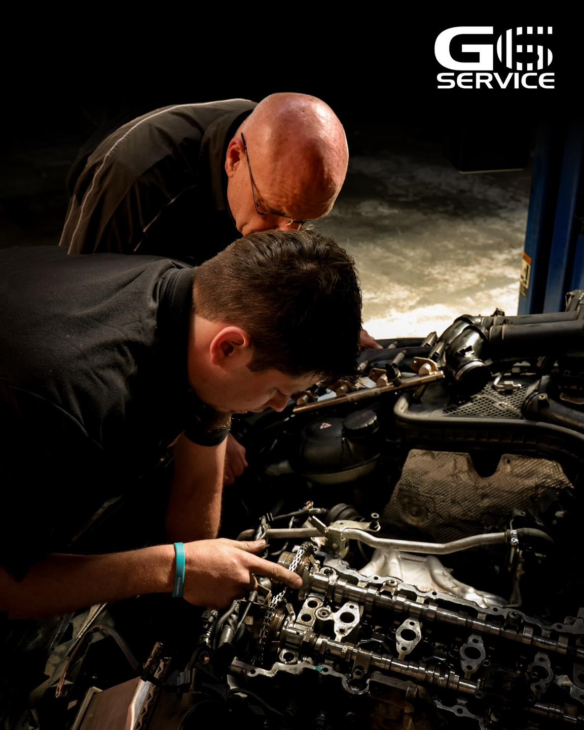 Two G6 Service technicians working together on a vehicle engine bay